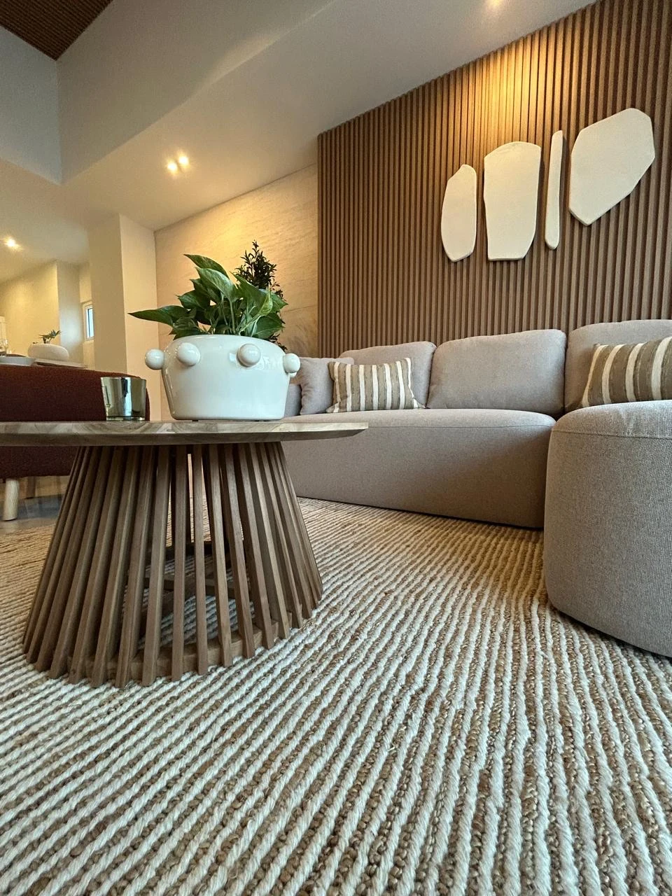 Detalle del mobiliario, alfombra, accesorios y revestimiento de madera de una sala terminada